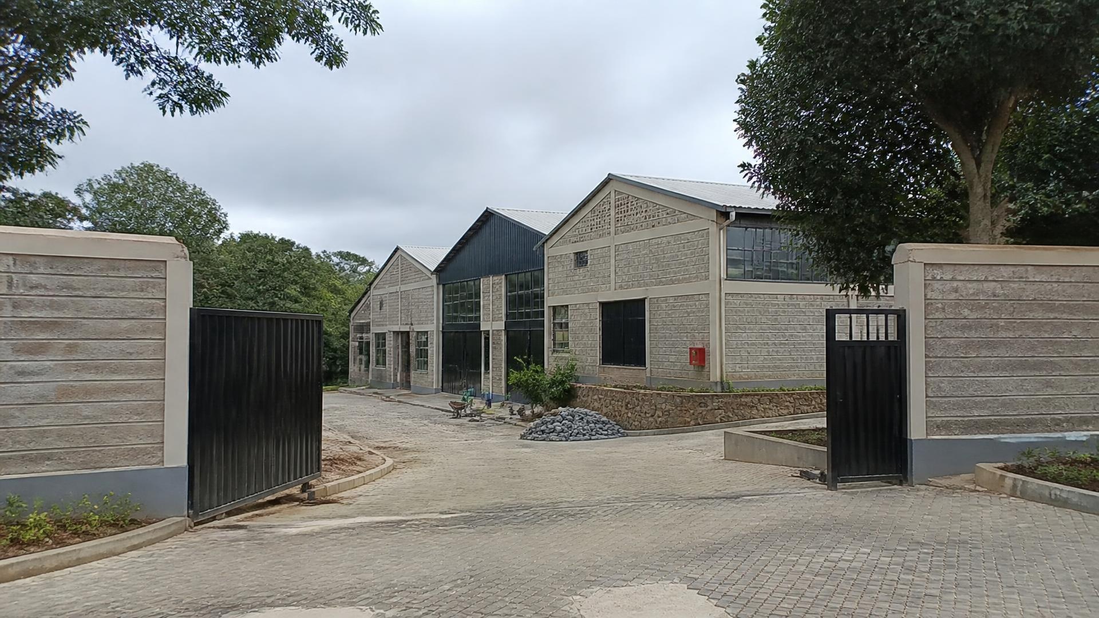 Project-aligned construction imagery for Winds of Change Foundation — godowns & gate, Karen